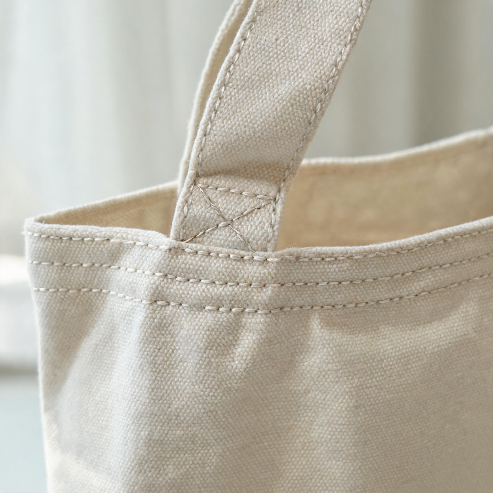Reinforced X-stitched handle attachment and double-stitched top hem